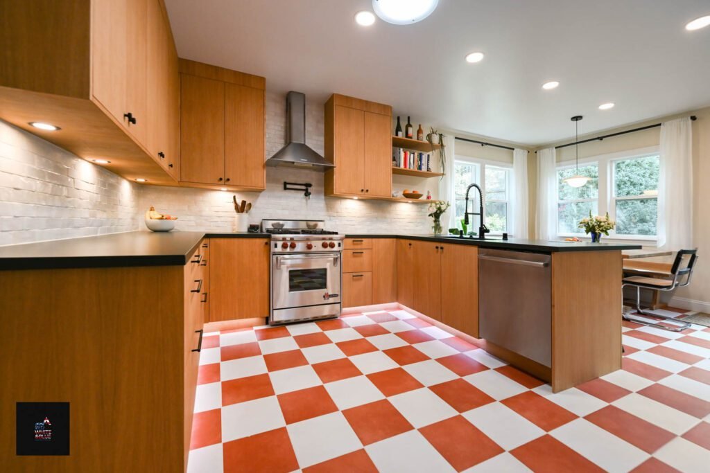 kitchen with stainless steel appliances, warm cabinetry, and checkerboard flooring