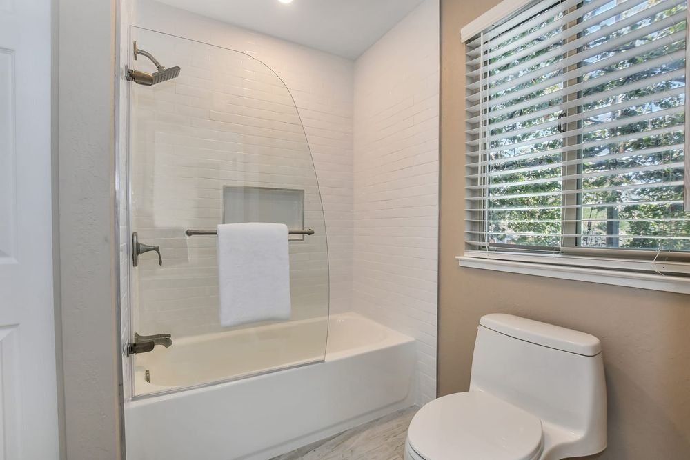 bathroom remodel with subway shower tile and curved glass